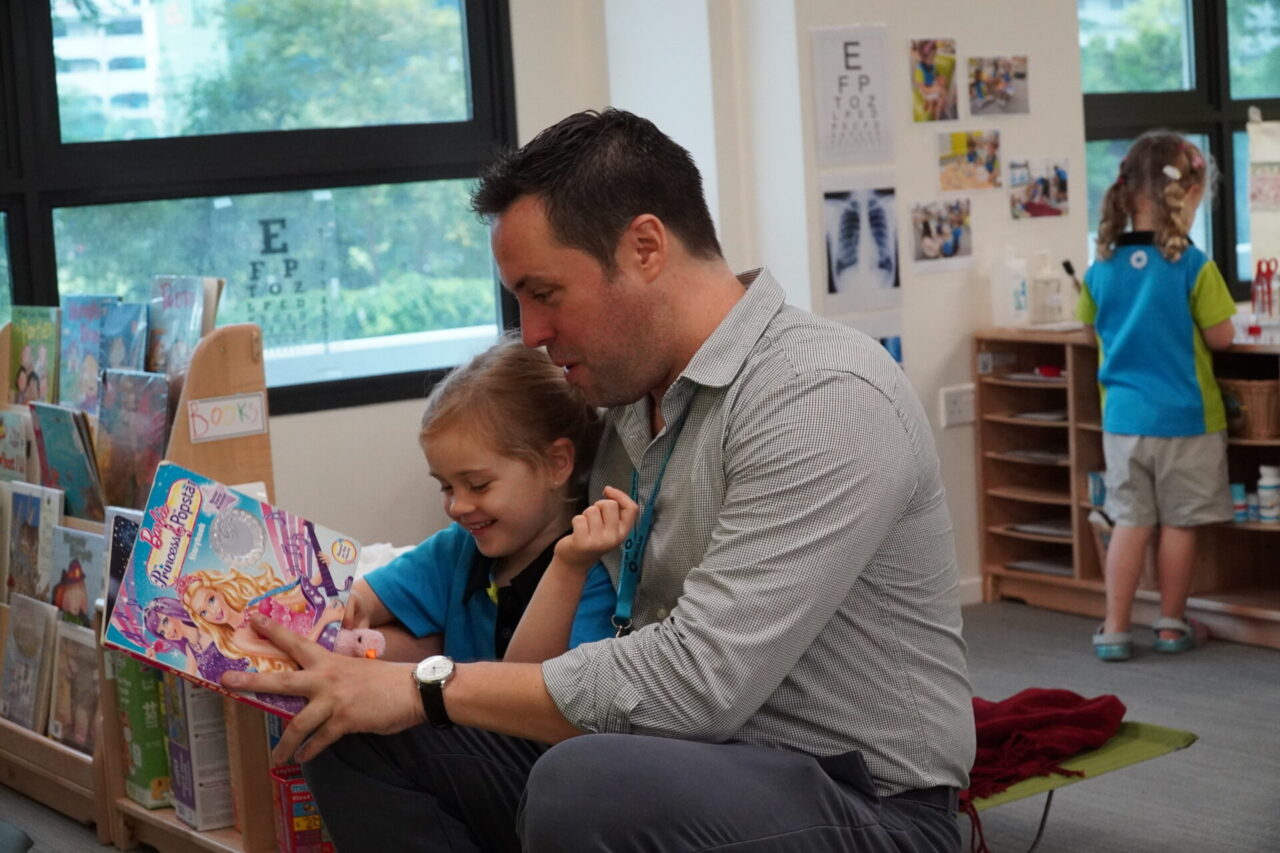 Father reading a storybook with his daughter