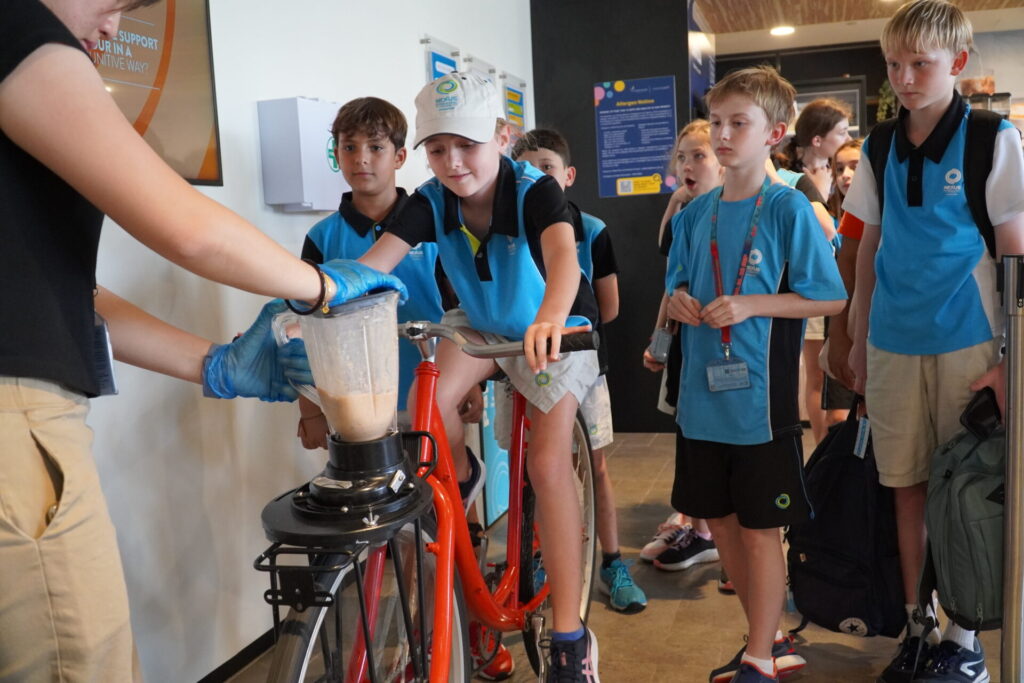 Students using a smoothie bike to generate electricity to make their own smoothie